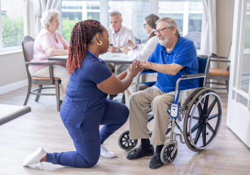 Sensatec fall device on wheelchair with nurse helping